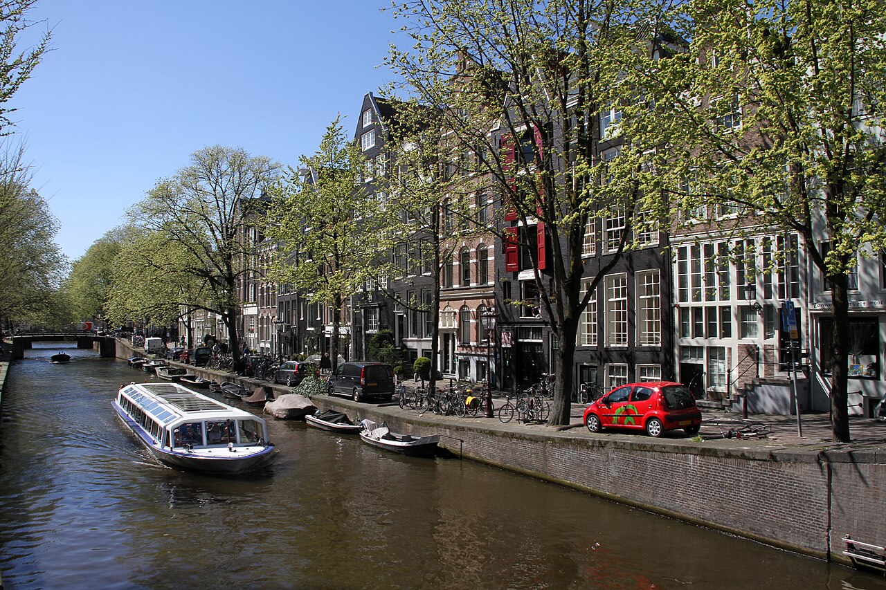Bateau de croisière sur la Leidsegracht, bordée d'arbres et de maisons de canal