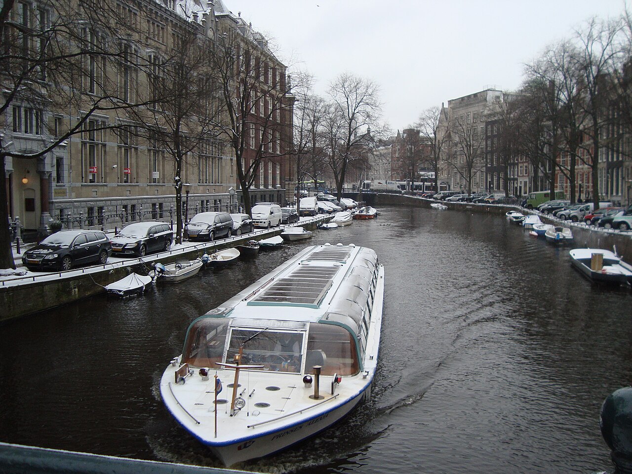 Un bateau-promenade sur un canal enneigé d'Amsterdam