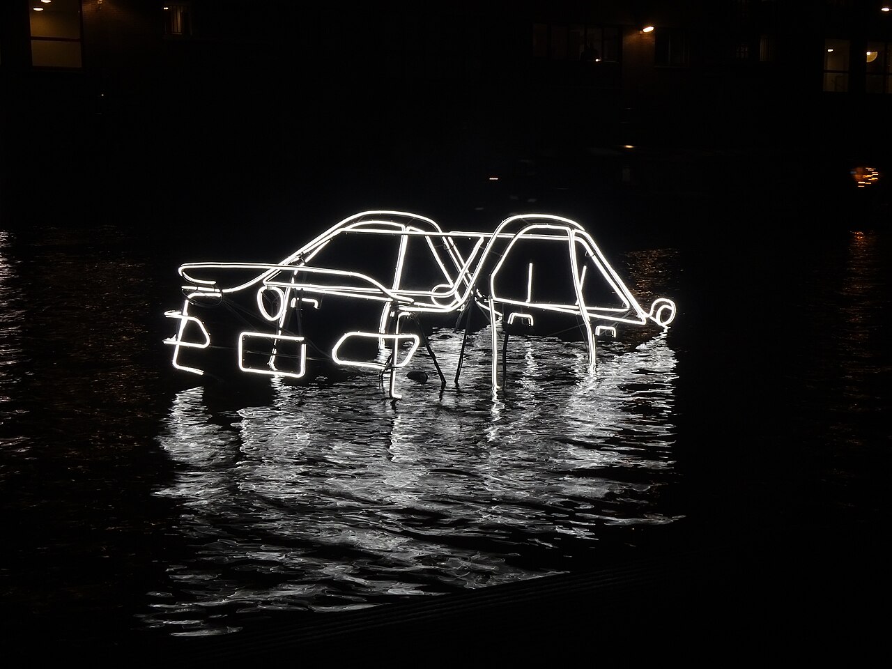 A light artwork shaped like a car floating on the water of the Entrepotdok during the Amsterdam Light Festival