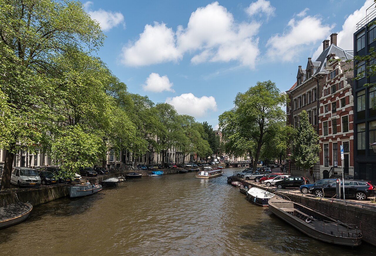 La Herengracht en été, bordée d'arbres et de bateaux