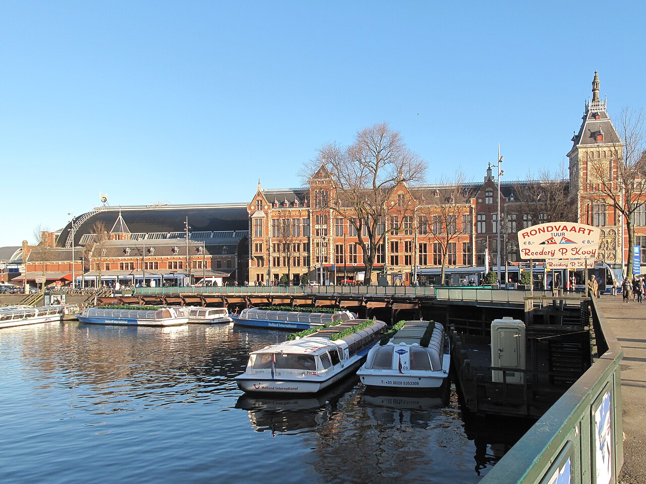 Barcos turísticos amarrados frente a la estación central de Ámsterdam