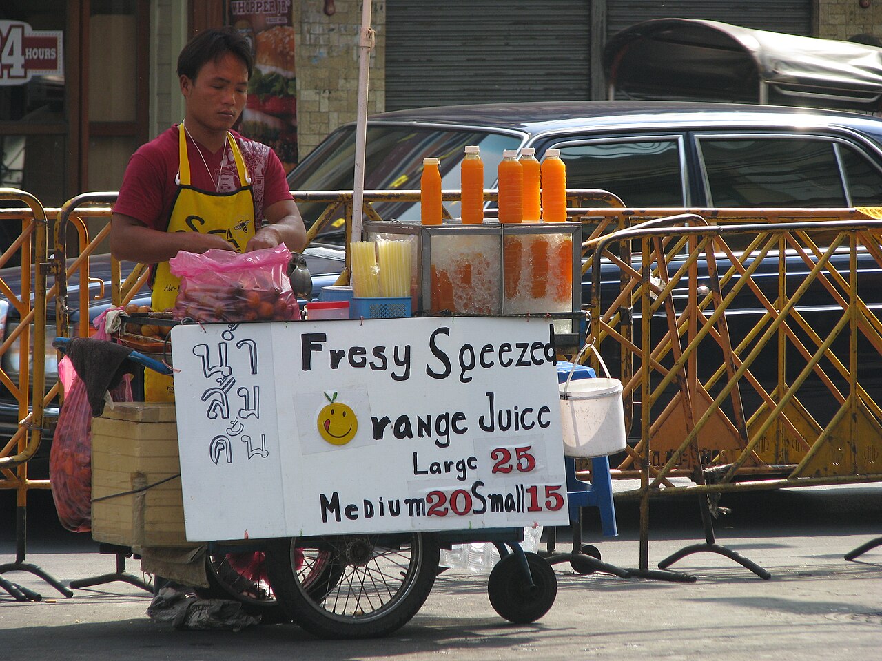 Vendeur de jus d'orange frais avec ses prix en bahts