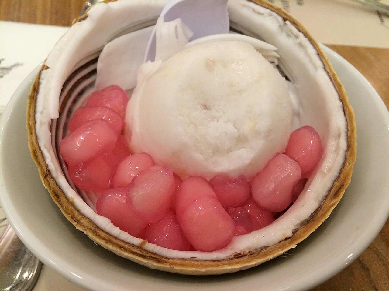 Coconut ice cream served in a coconut shell with pink pearls