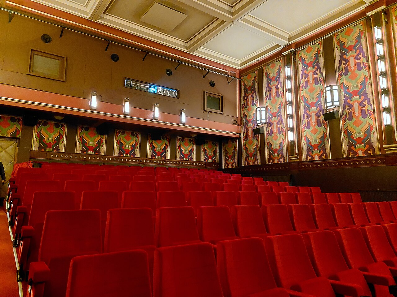 La grande salle Art déco du cinéma The Movies, ses fauteuils rouges et ses panneaux décorés