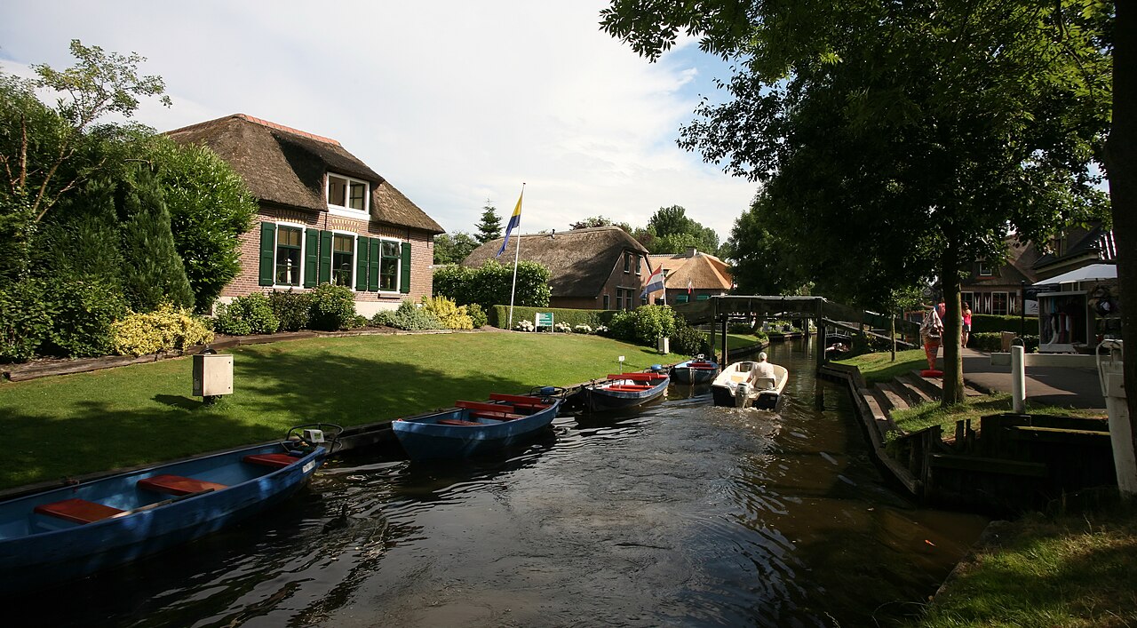 Canal bordé de maisons au toit de chaume à Giethoorn
