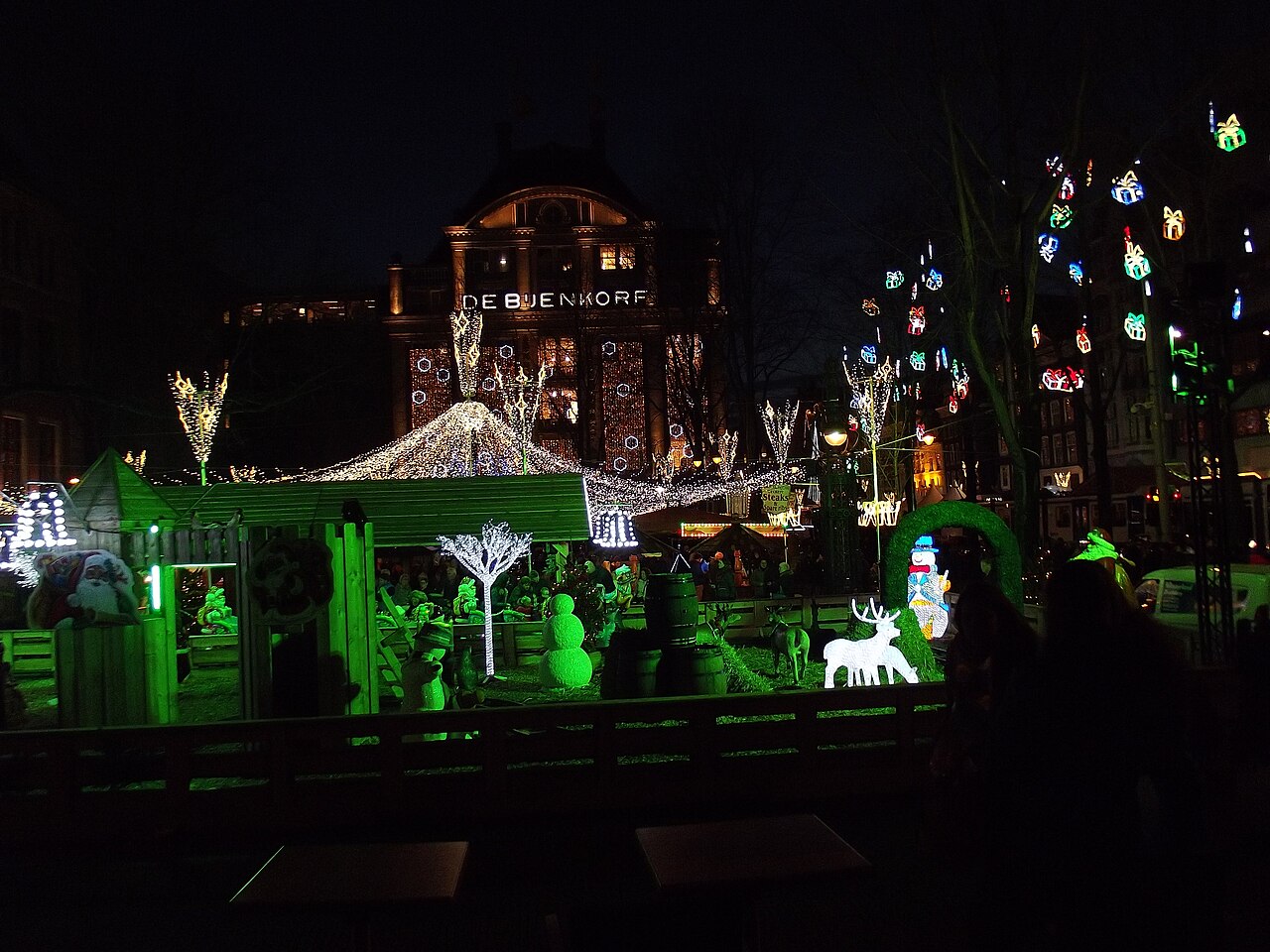 Décor de Noël sur la place du Dam en 2013, devant la façade illuminée du Bijenkorf