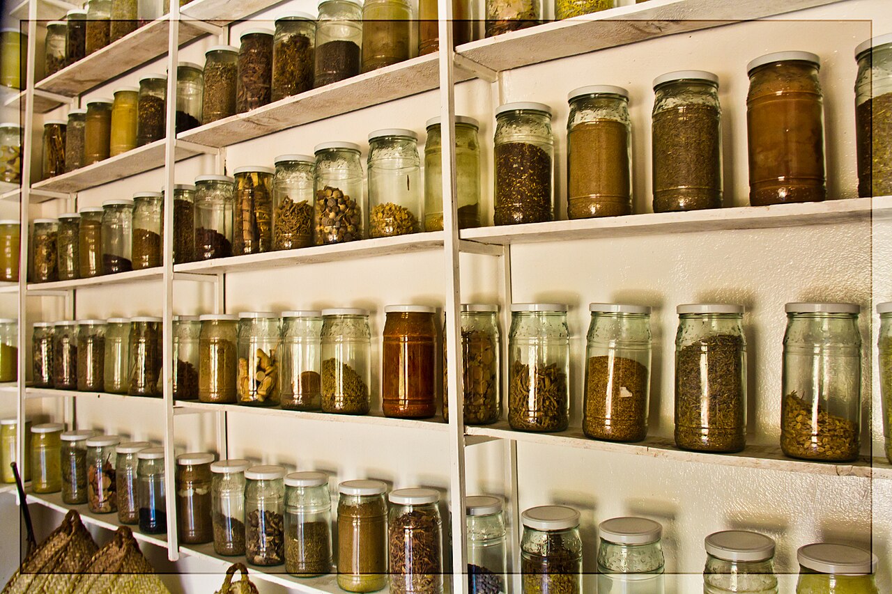 Bocaux de plantes et d'épices sur les étagères d'une herboristerie marocaine