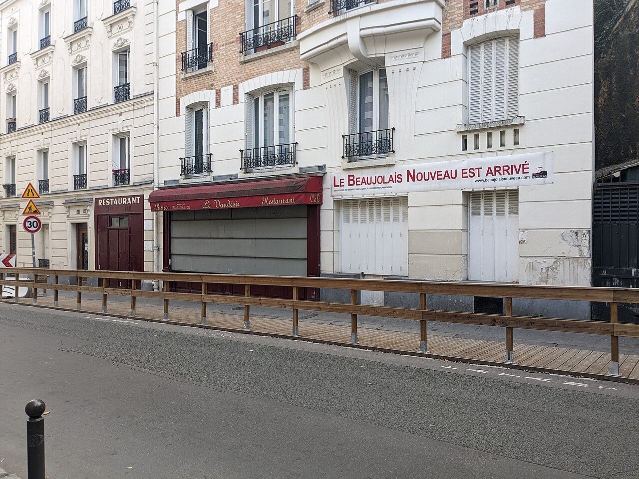A « Le Beaujolais nouveau est arrivé » banner on a façade in the 14th arrondissement