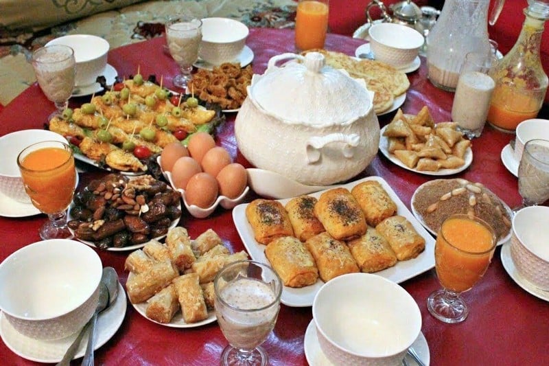 Table de ftour marocaine avec soupière de harira, dattes, œufs et briouates