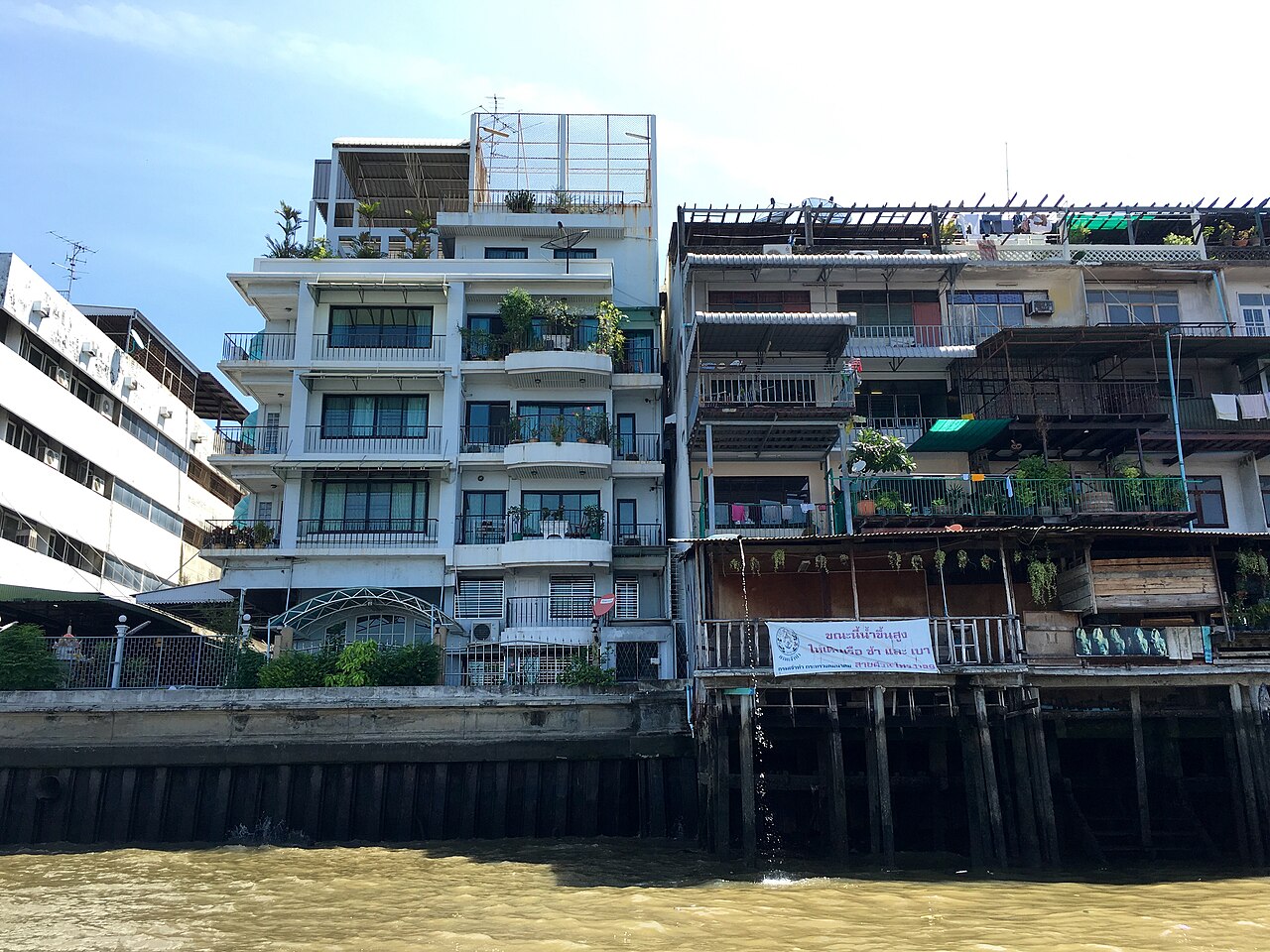 Maisons sur pilotis au bord du fleuve le long de Song Wat Road