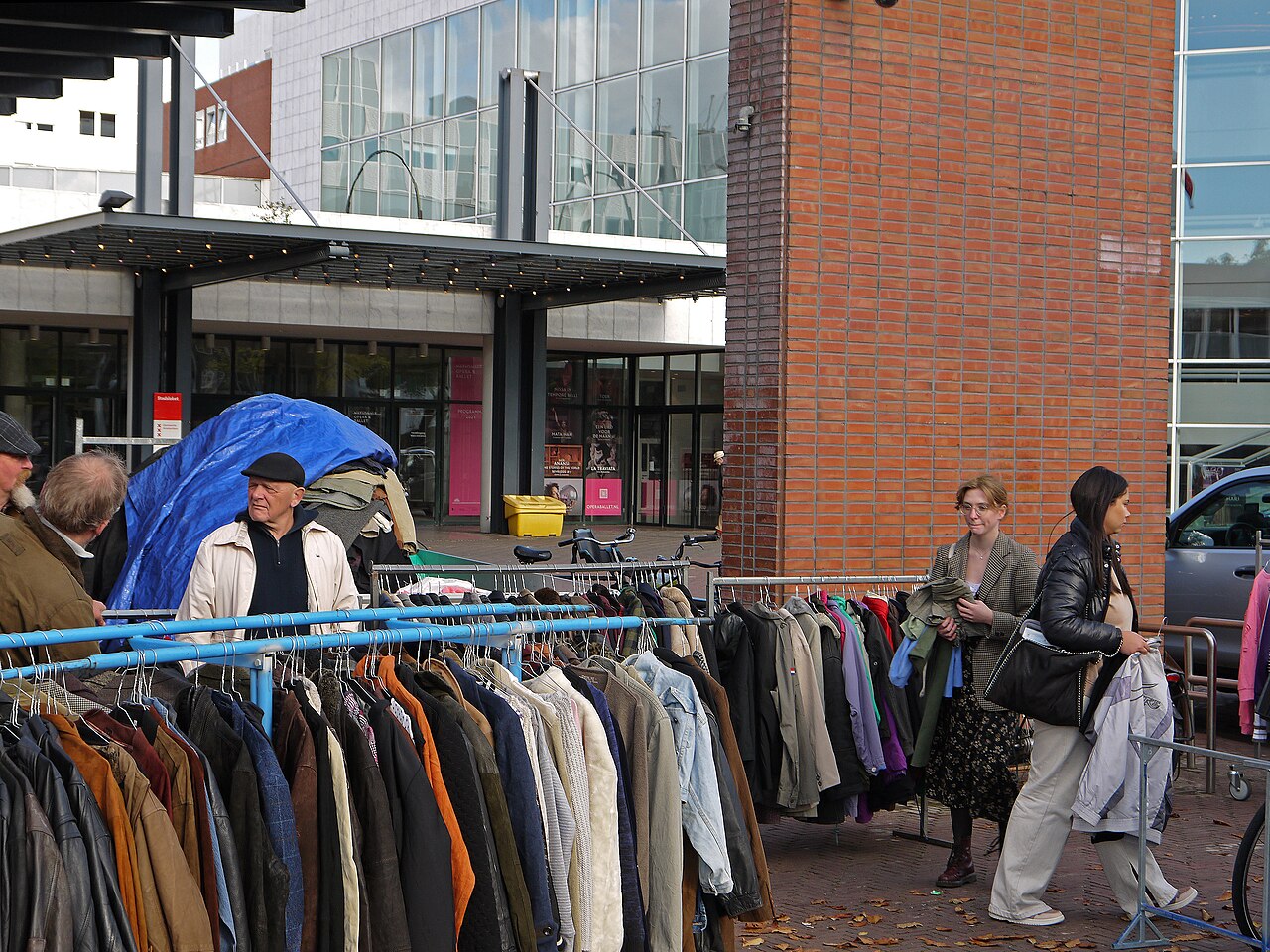 Racks of second-hand clothes at Waterlooplein market, in front of the Dutch National Opera