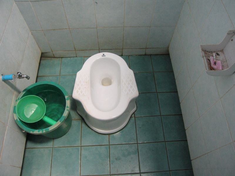 A Thai squat toilet with bucket and scoop