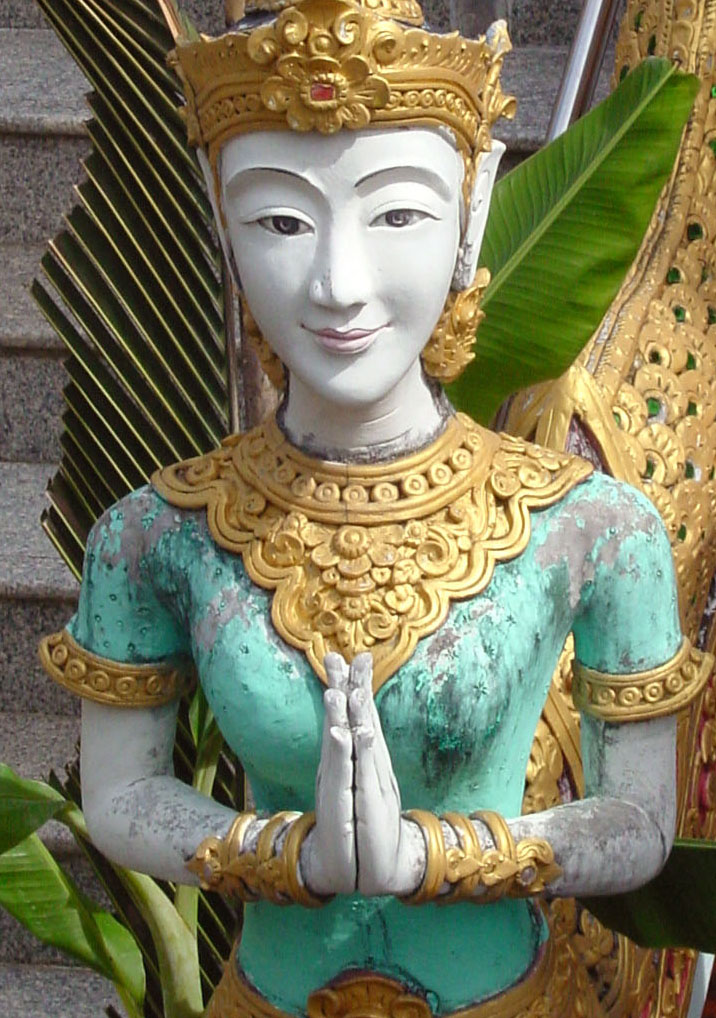 A Thai statue with palms together, the wai gesture