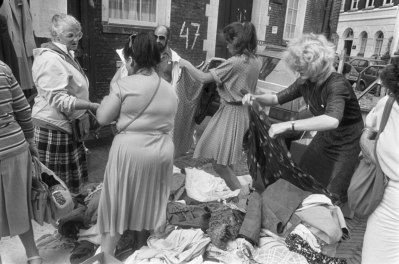 Women searching through a pile of second-hand clothes at the Noordermarkt market in 1983